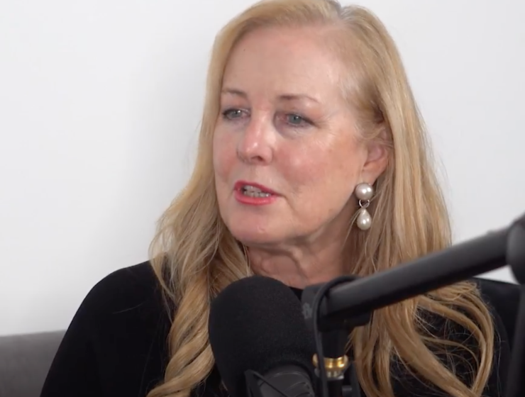 Woman sits at microphone.